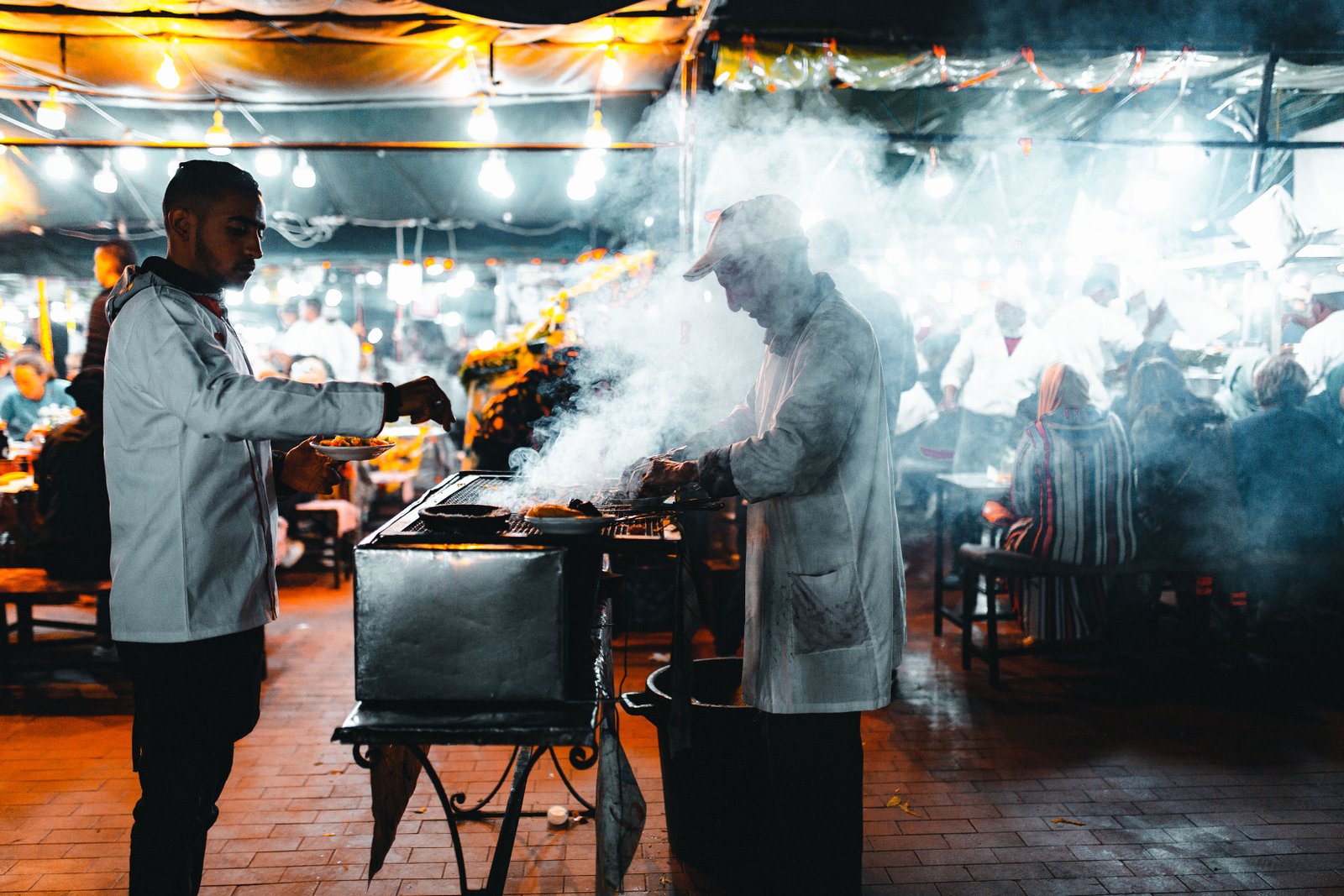 Cooks at a smoky food stall in the Marrakech night market, Morocco