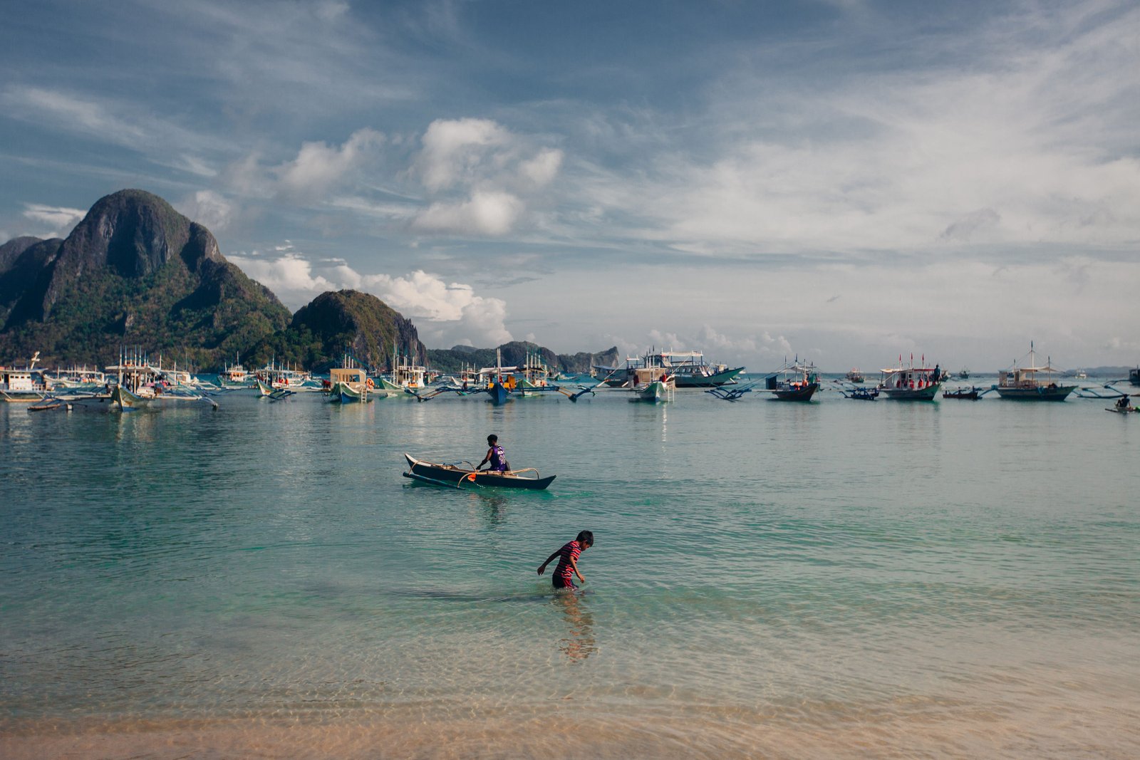 Bangka boats and kids in a bay in the Philippines